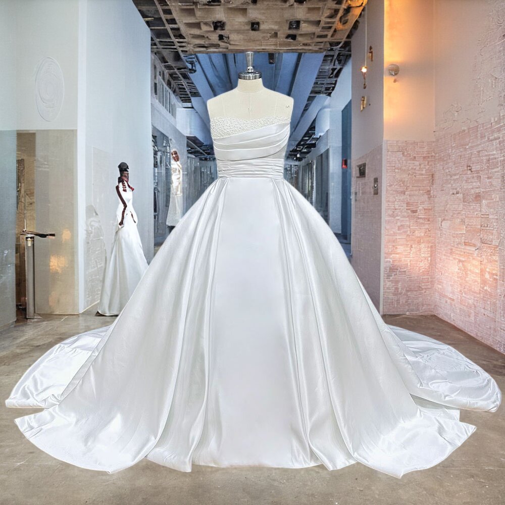 Premium white silk satin princess wedding dress displaying a crossover pleated bodice and structured off-the-shoulder straps, shown on a mannequin in a showroom.
