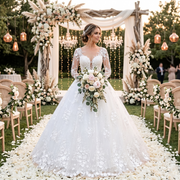 Bride wearing a long-sleeve floral lace ball gown wedding dress with intricate applique details at an outdoor garden ceremony.