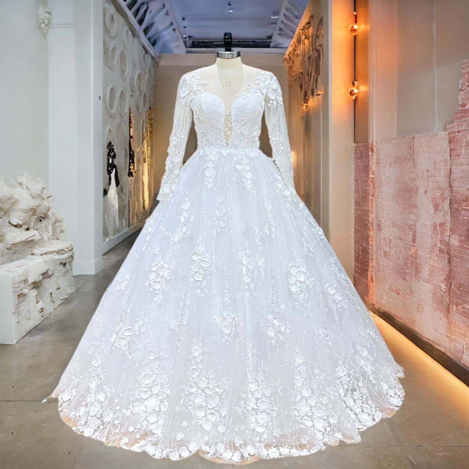 Full view of a long-sleeve floral lace ball gown wedding dress displayed on a mannequin in a professional bridal boutique.
