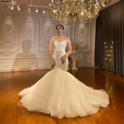 Full-length front view of a luxury long sleeve beaded mermaid bridal gown featuring an intricate crystalline bodice and a dramatic, voluminous ruffled tulle skirt.
