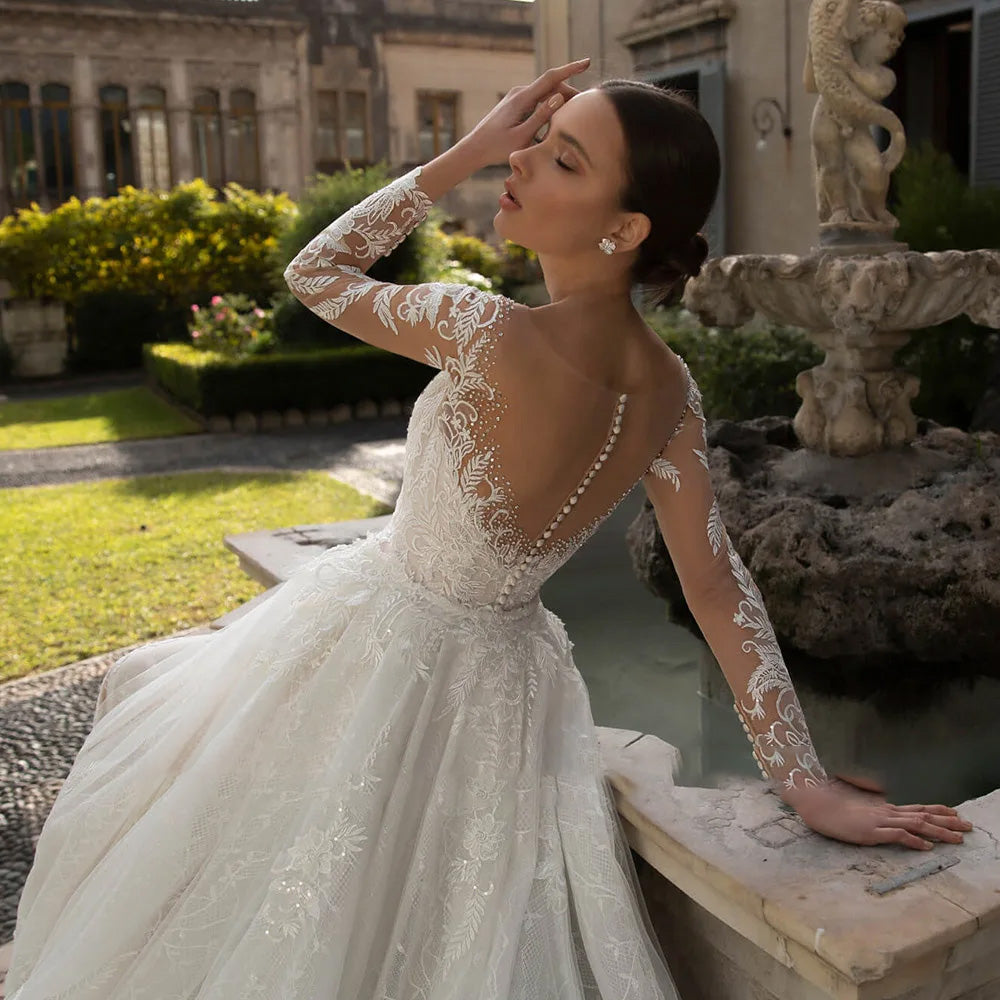 A mannequin displaying a high-end long-sleeve mermaid bridal gown with detailed sequins, beading, and a versatile detachable train.