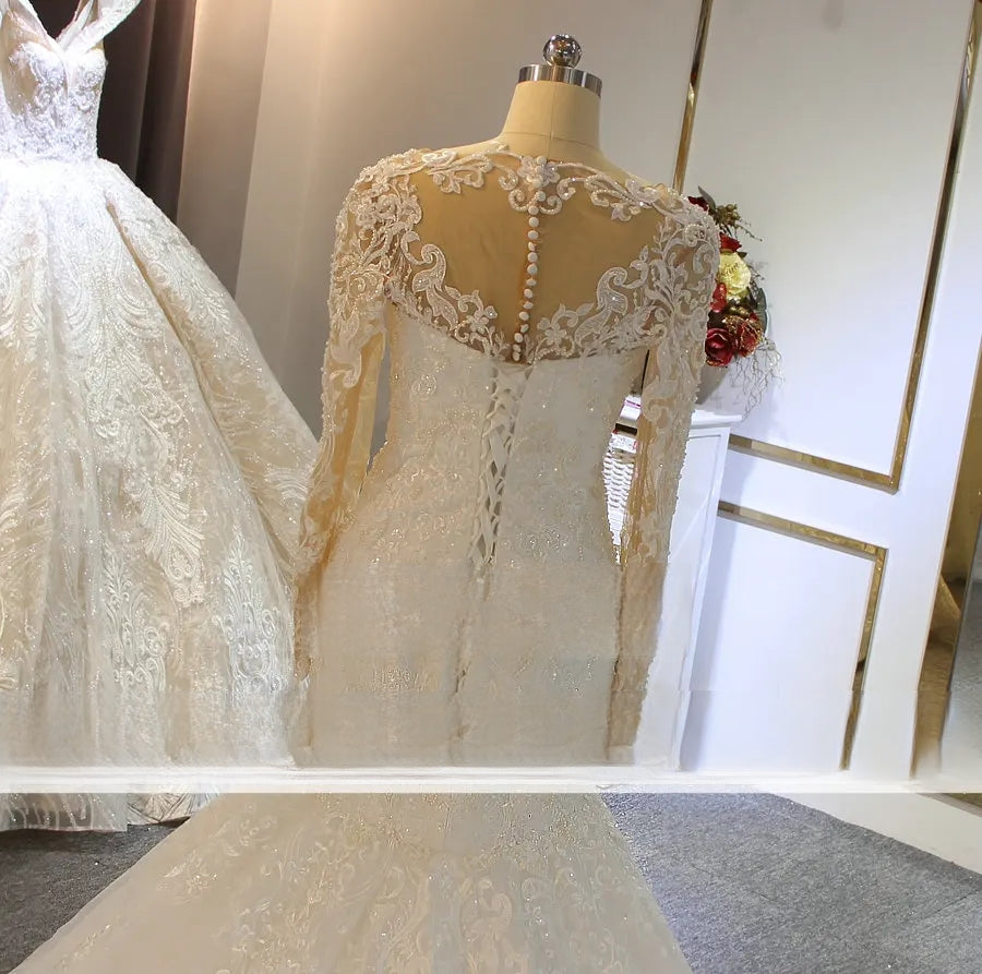 Close-up back view of a lace mermaid bridal gown, showcasing an intricate illusion lace back with center buttons and a sophisticated lace-up corset detail for a flattering silhouette.