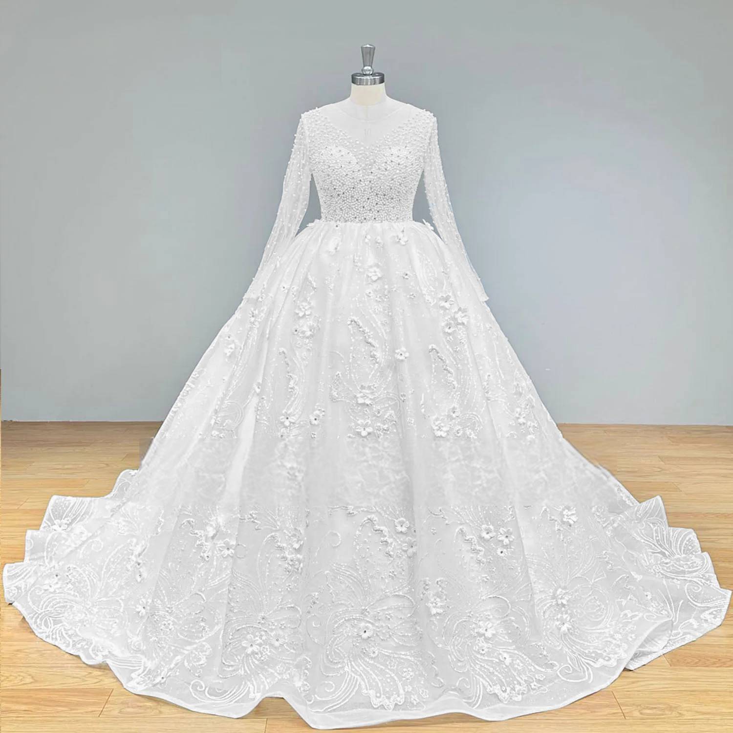 Front perspective of an opulent long sleeve beaded ball gown with 3D flowers, displayed on a mannequin to highlight the regal silhouette and intricate floral embroidery.