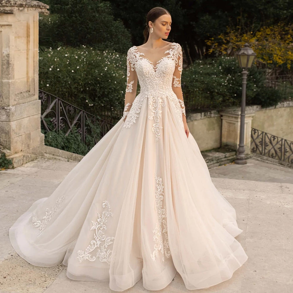 Elegant long sleeve lace vintage wedding dress featuring a sexy illusion neckline and intricate beadwork on an A-line skirt.