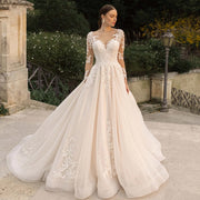 Elegant long sleeve lace vintage wedding dress featuring a sexy illusion neckline and intricate beadwork on an A-line skirt.