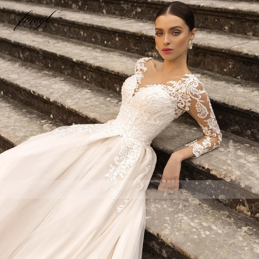 Close-up of a bride wearing a vintage-style long sleeve lace wedding dress with a detailed illusion neckline and beaded bodice.