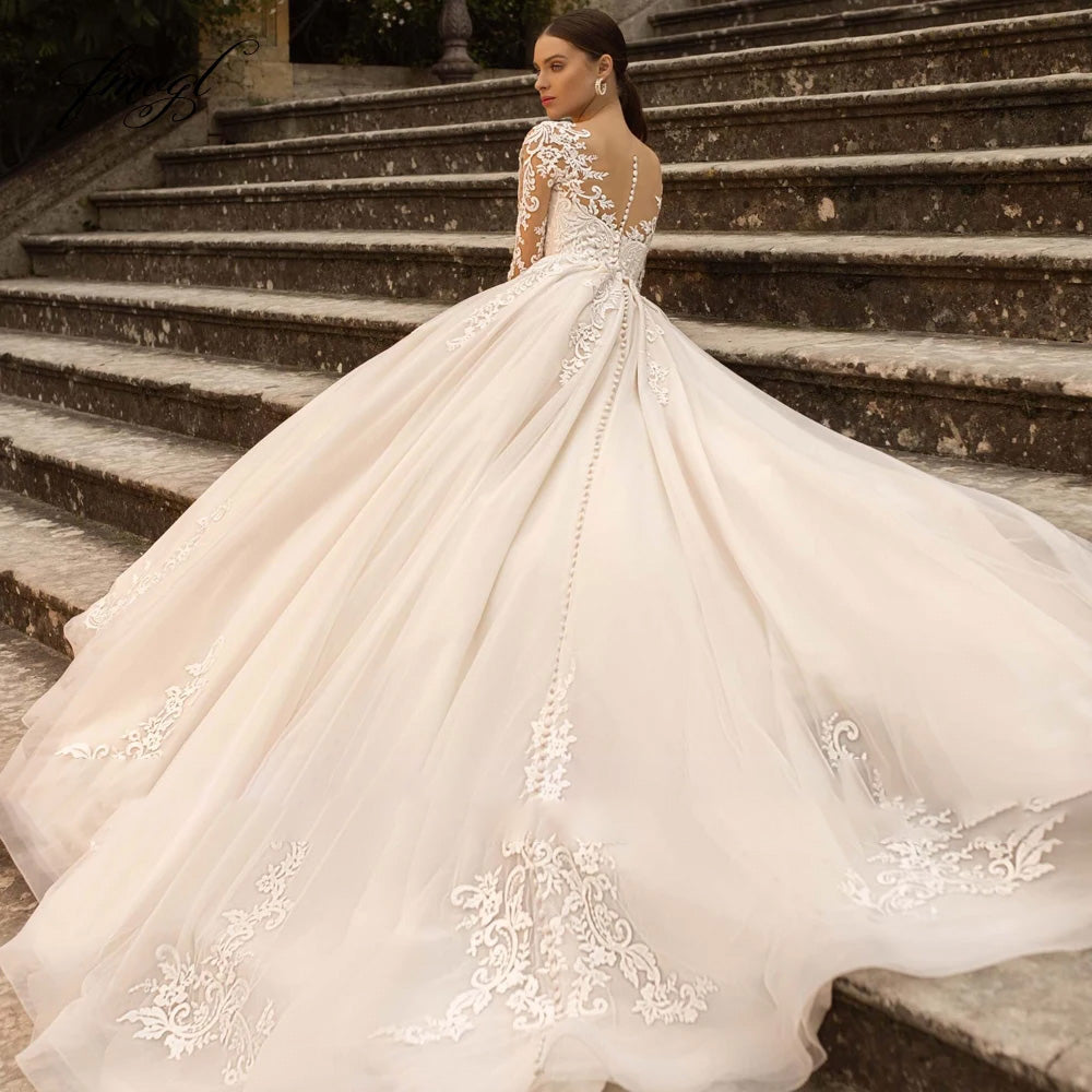 Back view of a vintage lace A-line wedding dress with a dramatic court train, illusion back, and delicate button detailing.