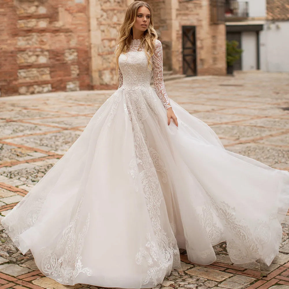 Front profile of an elegant bride in a long sleeve lace wedding dress, showcasing a classic scoop neck and intricate lace detailing.
