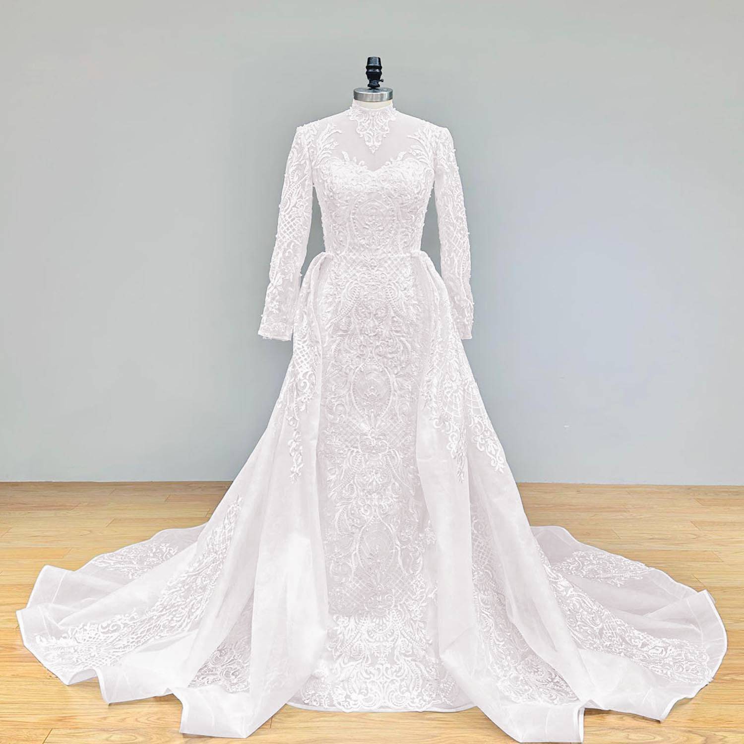 Full front profile of an elegant long-sleeve mermaid wedding dress with detachable train, displayed on a professional mannequin.