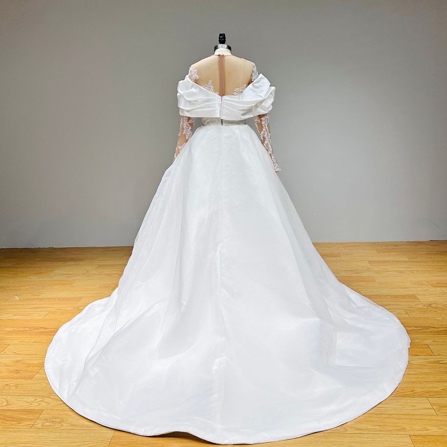 Back view of a 2-in-1 wedding dress showcasing the clean, sweeping lines of a satin detachable cathedral train and a sheer illusion back panels.