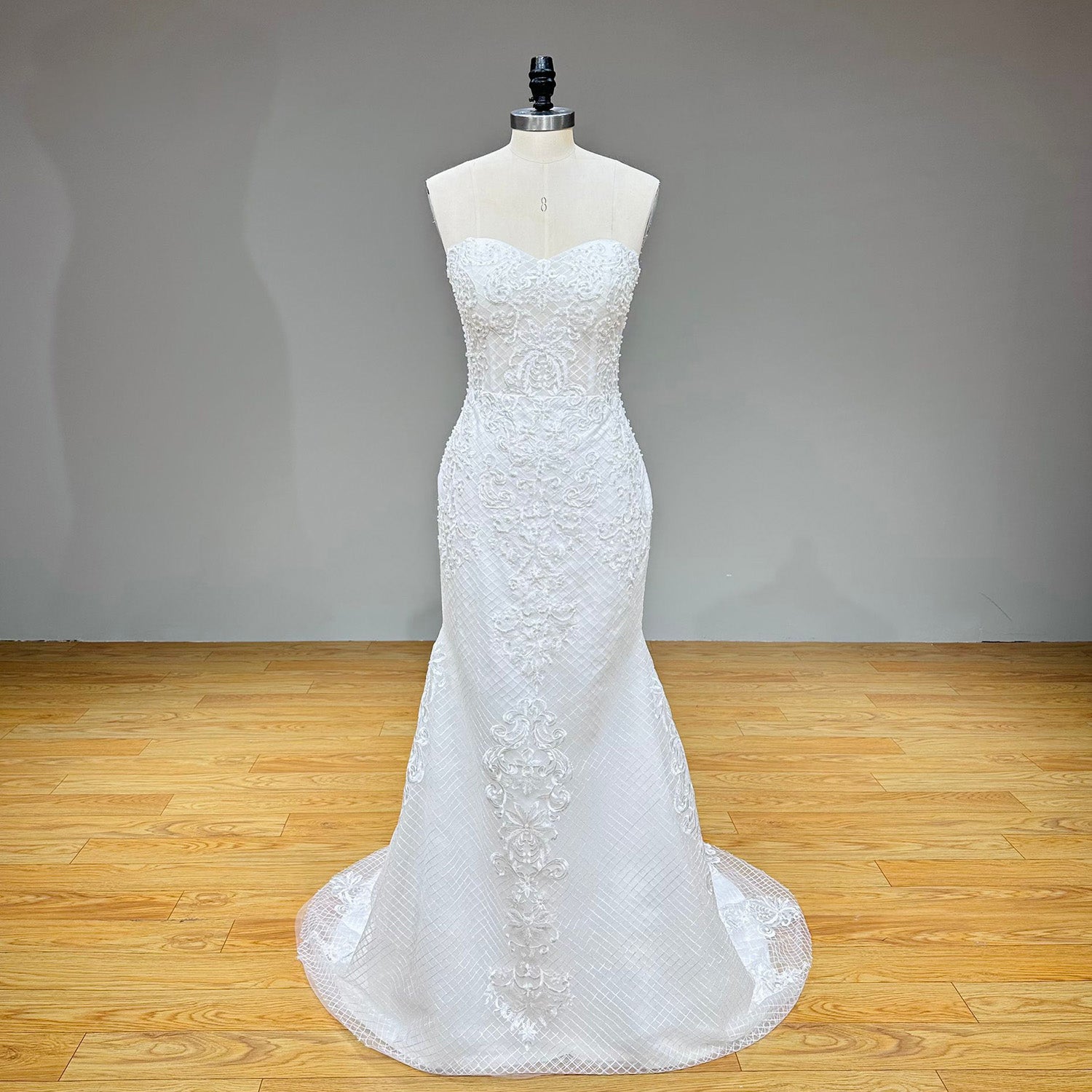 Full-length studio front view of the strapless sweetheart mermaid wedding dress on a mannequin, showcasing the fitted silhouette without the removable jacket.