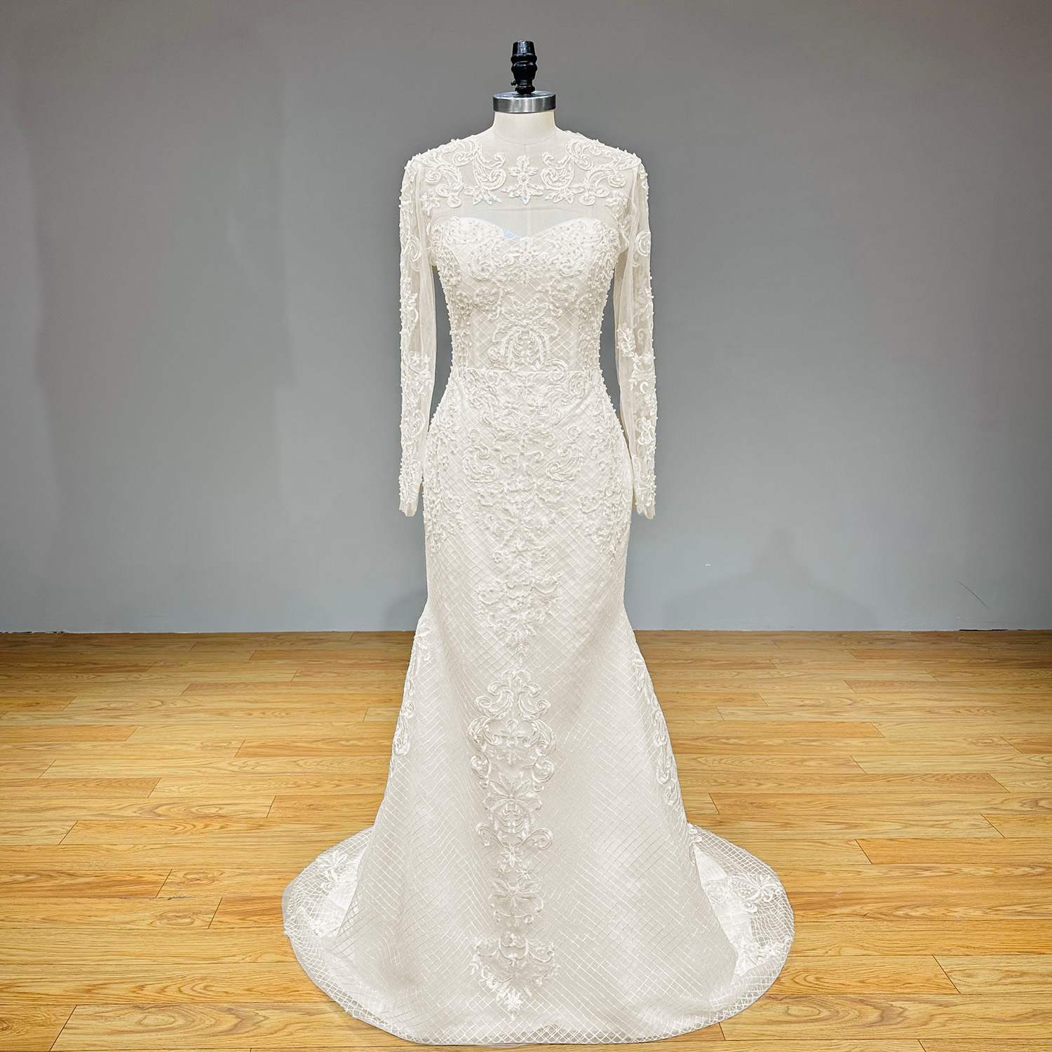 Complete front product shot of the long sleeve mermaid wedding gown with a removable sheer high-neck lace jacket on a studio mannequin.