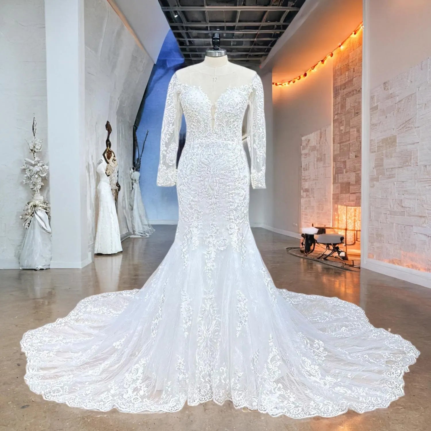 Full-length front view of the mermaid bridal gown on a mannequin, highlighting the fitted bodice with symmetrical floral lace patterns and an expansive lace-trimmed train.