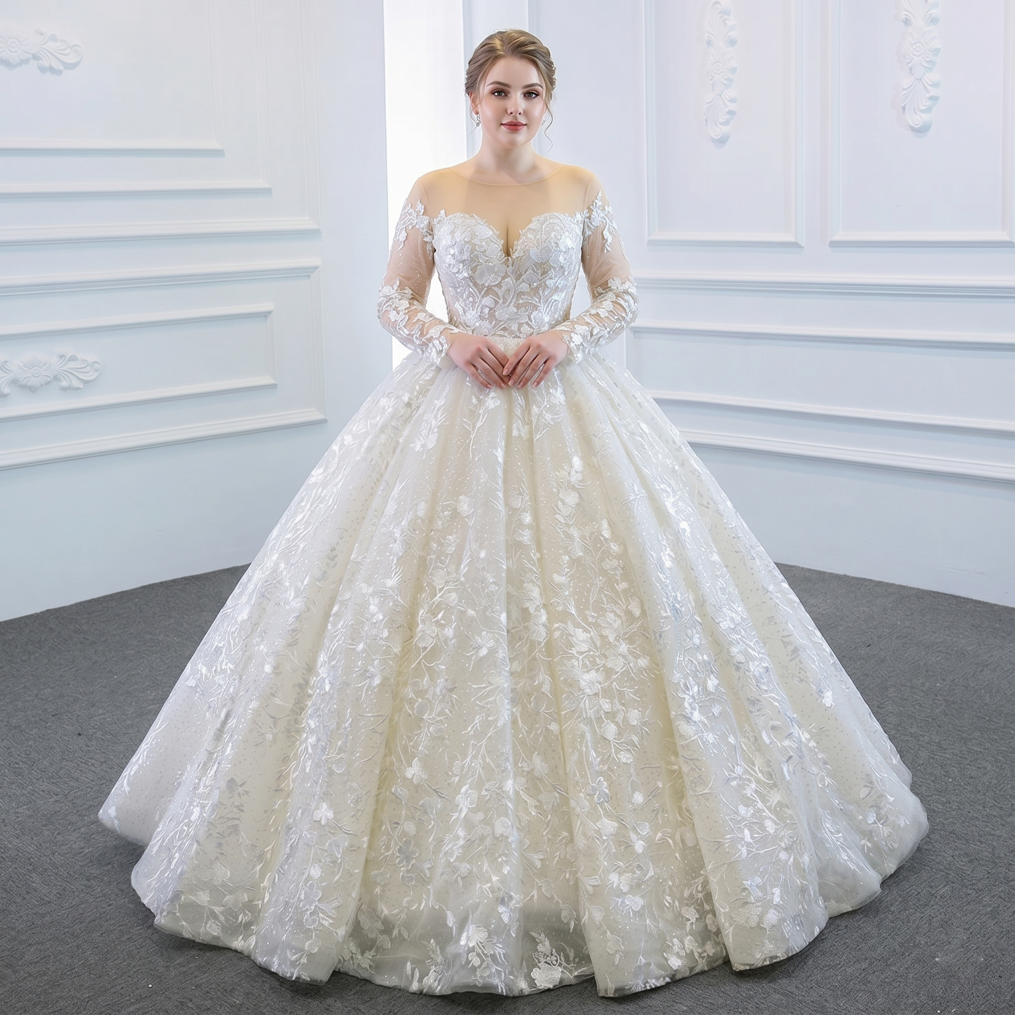 Plus-size model showcasing a long sleeve bridal gown featuring a transparent illusion neckline, structured sweetheart bodice, and a voluminous ball gown skirt with white floral embroidery.