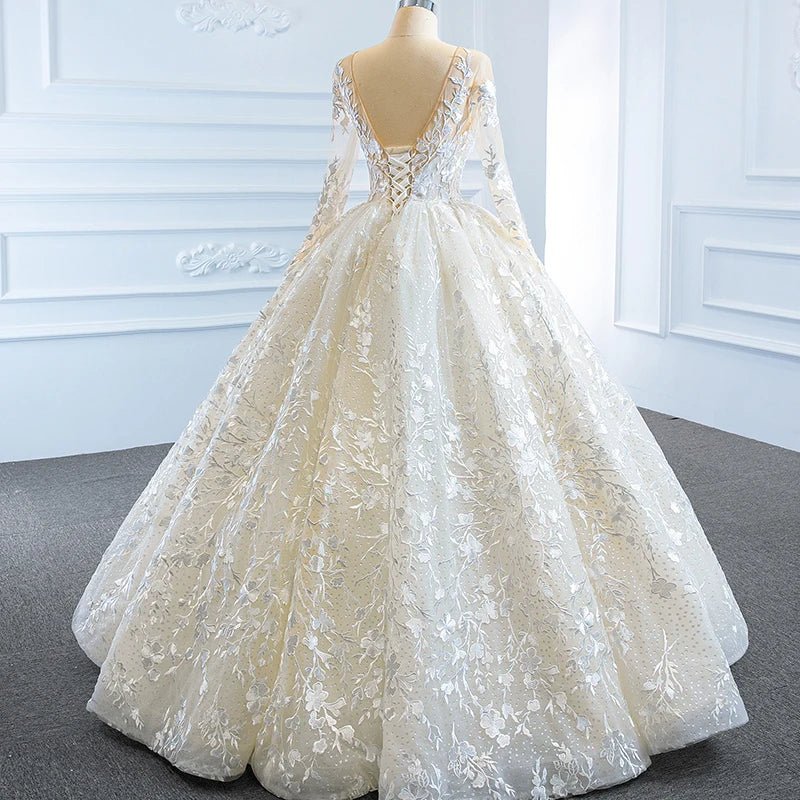 Detailed back view of a luxury wedding gown, focusing on the intricate ribbon lace-up corset back and trailing floral appliques over sheer mesh.
