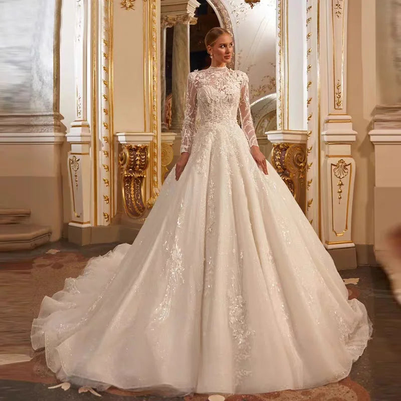 A bride wearing a luxury A-line long-sleeve wedding dress with a high neck, intricate lace applique, and a full ball gown skirt.