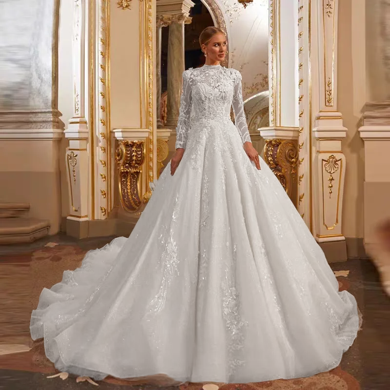 Full view of an elegant A-line long-sleeve wedding dress with high neck and delicate lace appliques, captured in a classic, ornate indoor setting.