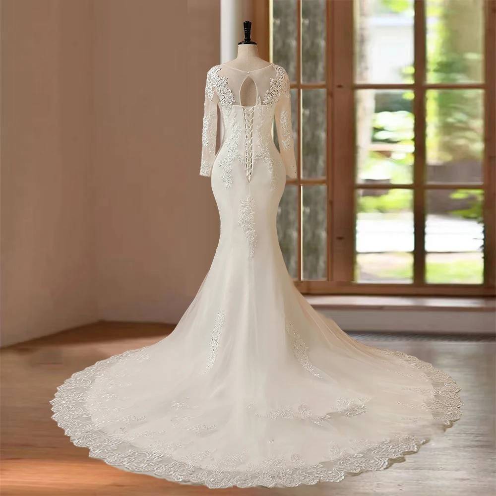 Back view of a women's long sleeve mermaid wedding dress on a mannequin featuring a delicate keyhole lace back cutout, corset lace-up closure, and a stunning circular lace-trimmed train.