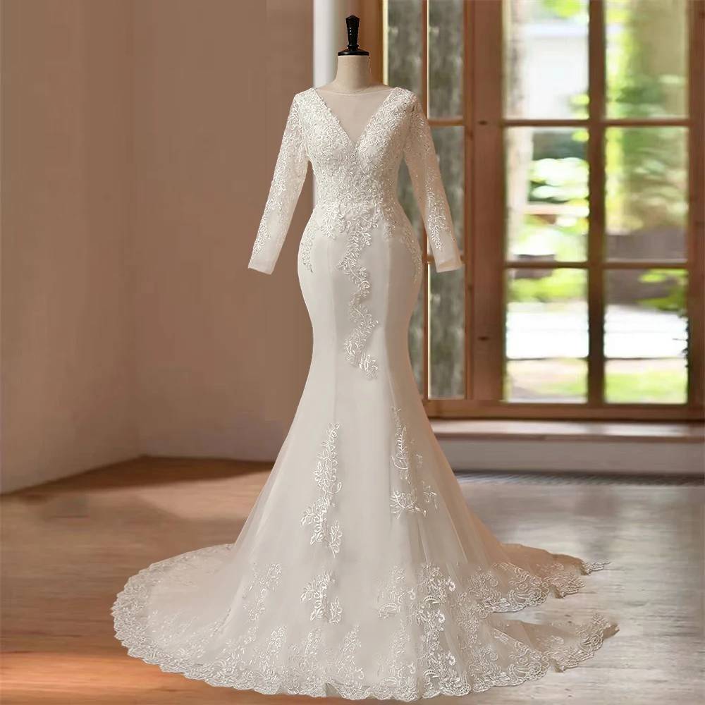 Classic full-length front shot of a formal long sleeve O-neck mermaid wedding dress on a mannequin, highlighting the seamless transition from the heavily appliquéd bodice to the wide, lace-edged hemline.