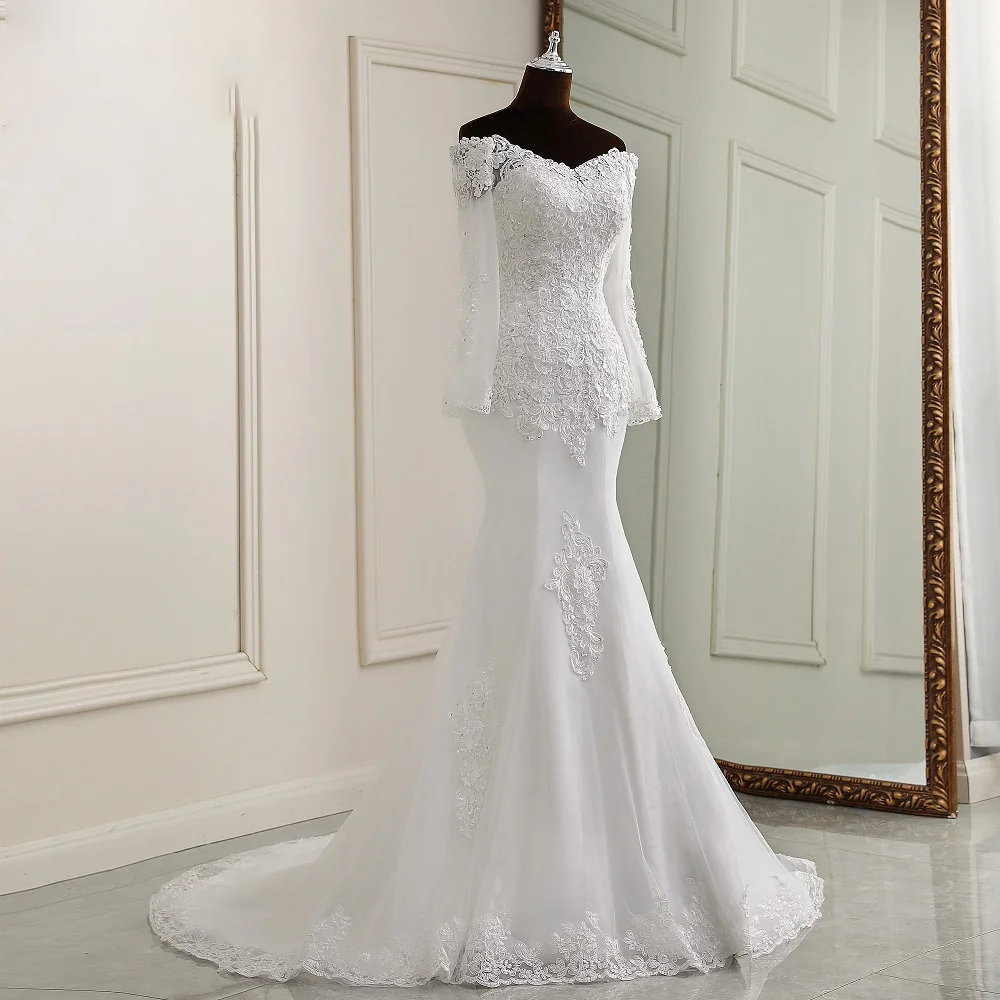 A mannequin display of a white, off-the-shoulder, long-sleeve mermaid wedding dress with ornate lace appliques and a flattering silhouette.