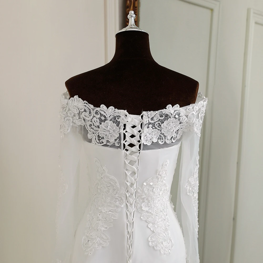 A detailed close-up of the back of an off-the-shoulder, long-sleeve mermaid wedding dress, highlighting the lace-up corset closure and intricate lace detailing.