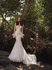 Detailed close-up of a glamorous lace bridal bodice highlighting the structured sweetheart neckline, intricate beaded embroidery, and sheer long sleeves finished with plush white feather trim.