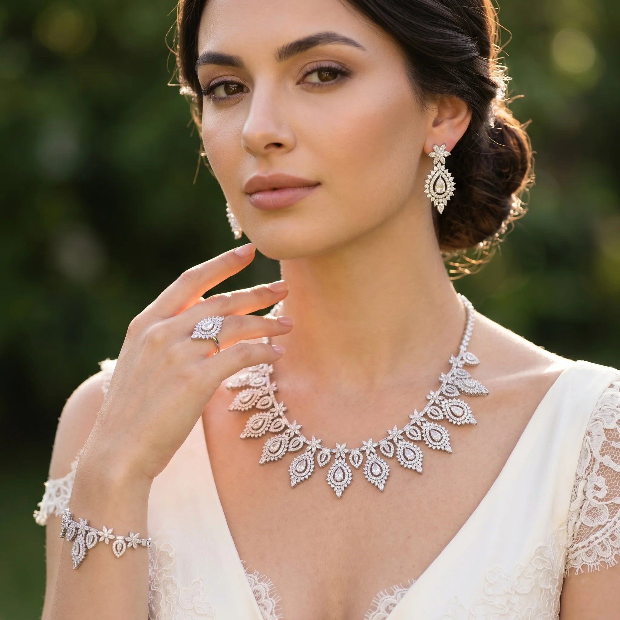 Smiling model wearing a luxury AAA zirconia bridal jewelry set with matching teardrop necklace, chandelier earrings, bracelet, and ring.