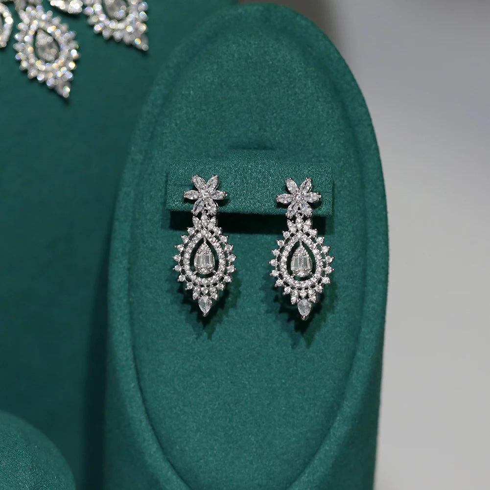 Elegant cubic zirconia bridal ring with a teardrop centerpiece stone displayed on a green velvet stand.