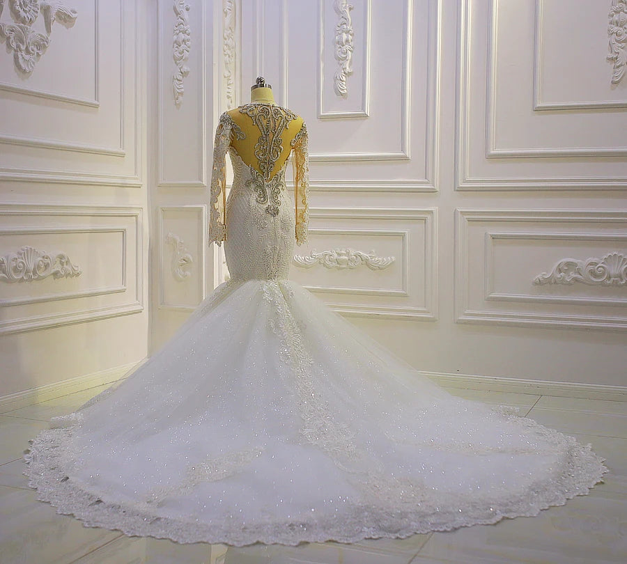 Majestic back view of a real bride showcasing the expansive tiered ruffled cathedral train and high-end beadwork of a luxury African wedding gown.