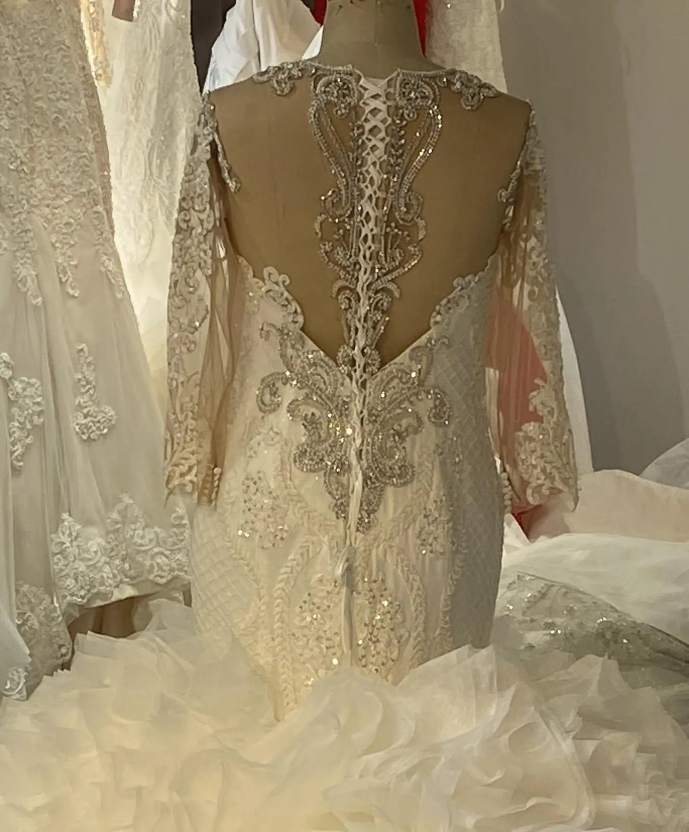 Detailed close-up of a bride in a high-neck long-sleeve wedding dress, emphasizing the intricate silver hand-beading and luxury sequin craftsmanship.