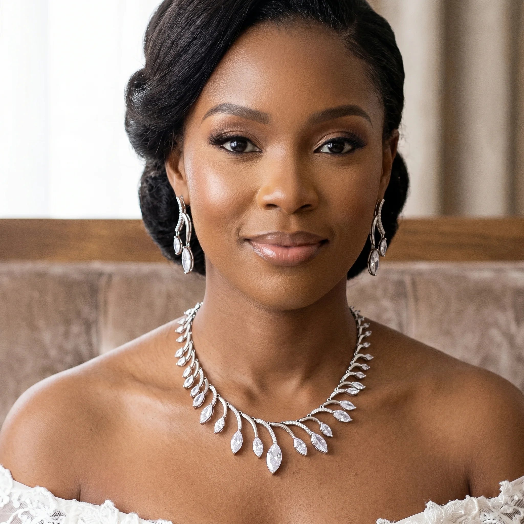 Close-up portrait of a smiling bride wearing a luxury African bridal jewelry set with a round marquise crystal necklace and wave-design earrings.