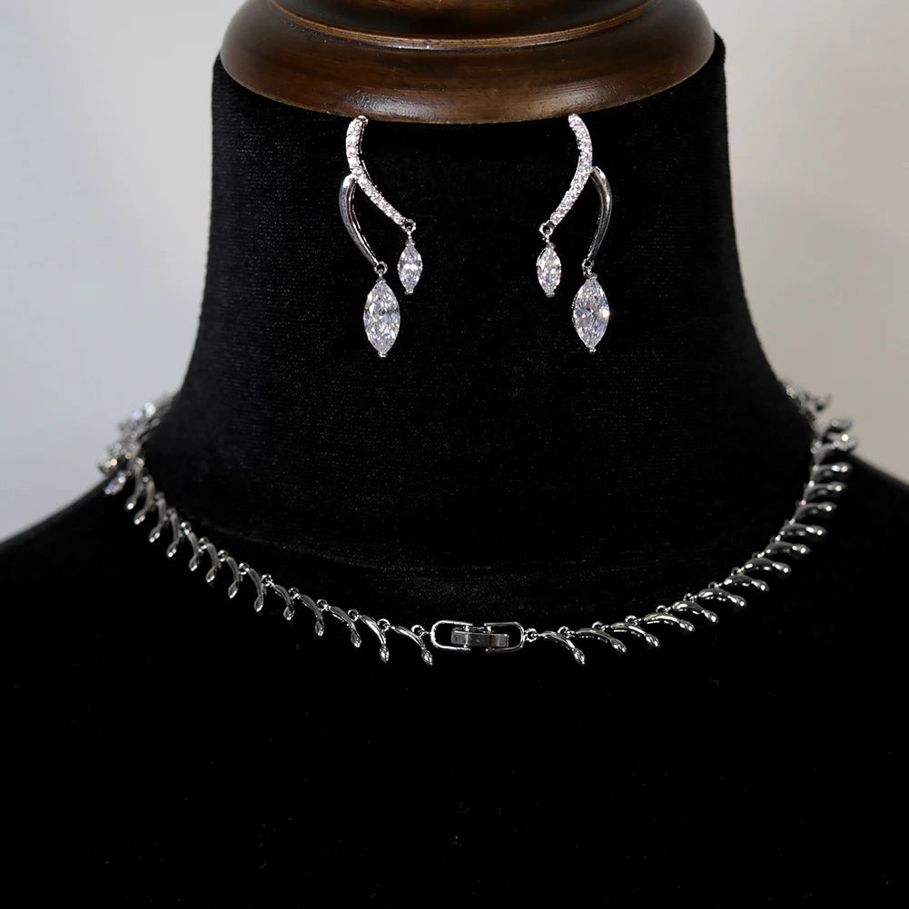 Rear angle view showcasing the secure clasp closure of a silver round necklace chain alongside wave-style bridal earrings.