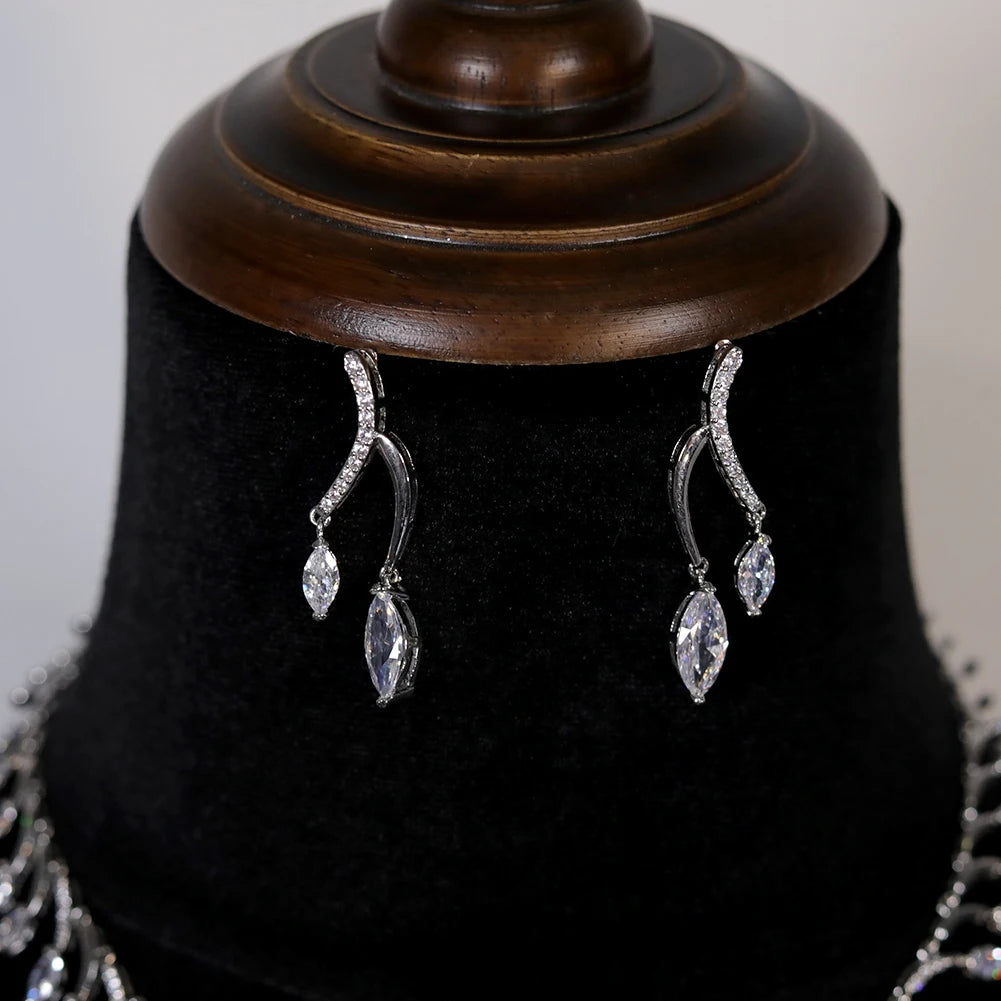 Close-up shot of elegant wave-motif cubic zirconia dropdown statement earrings from a bridal wedding collection.