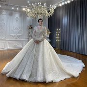 Full front view of a model wearing a luxury beaded ball gown wedding dress with long sleeves and an elegant removable high-neck illusion collar featuring a massive cathedral train.