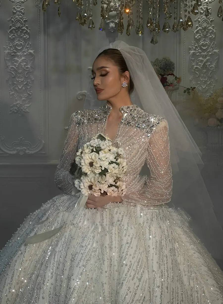 Macro detail shot of a luxury bridal bodice featuring expert hand-beaded silver crystals, sequins, and 3D shimmering lace patterns.
