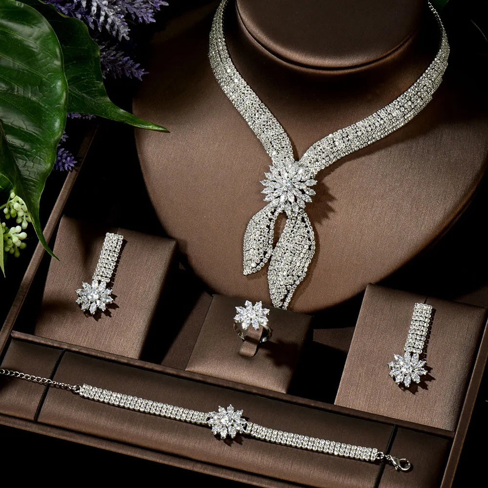 Complete 4-piece cubic zirconia bridal wedding jewelry set featuring a statement necklace, link bracelet, drop earrings, and a cocktail ring displayed in a luxury brown box.