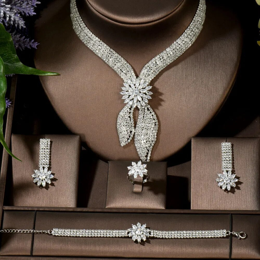 Studio display of the complete silver cubic zirconia bridal suite layout including the starburst blossom ring, matching earrings, bracelet, and collar necklace.