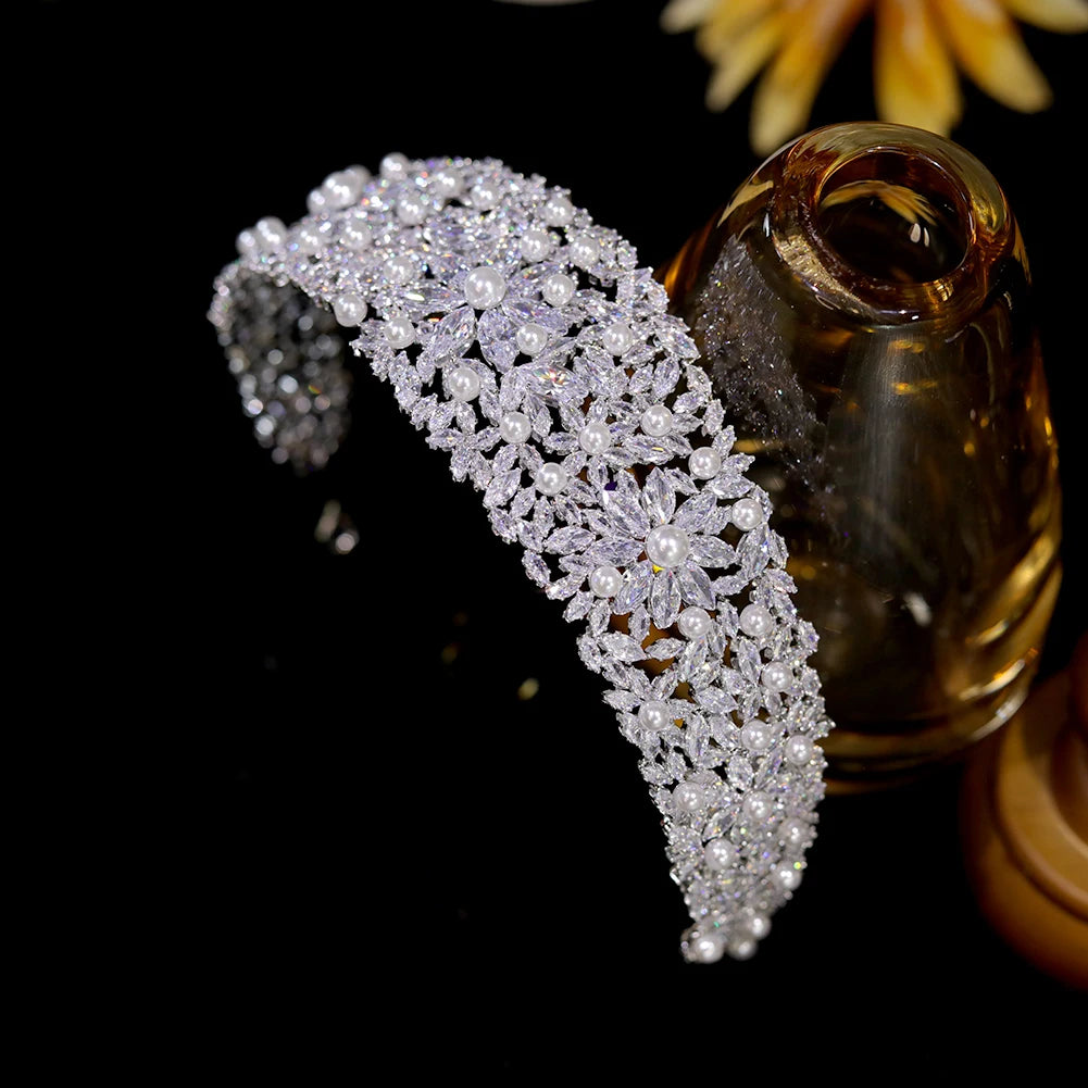 High-angle perspective view of the wide silver wedding flower crown headband decorated with clear cubic zirconia marquise stones and round white pearls.