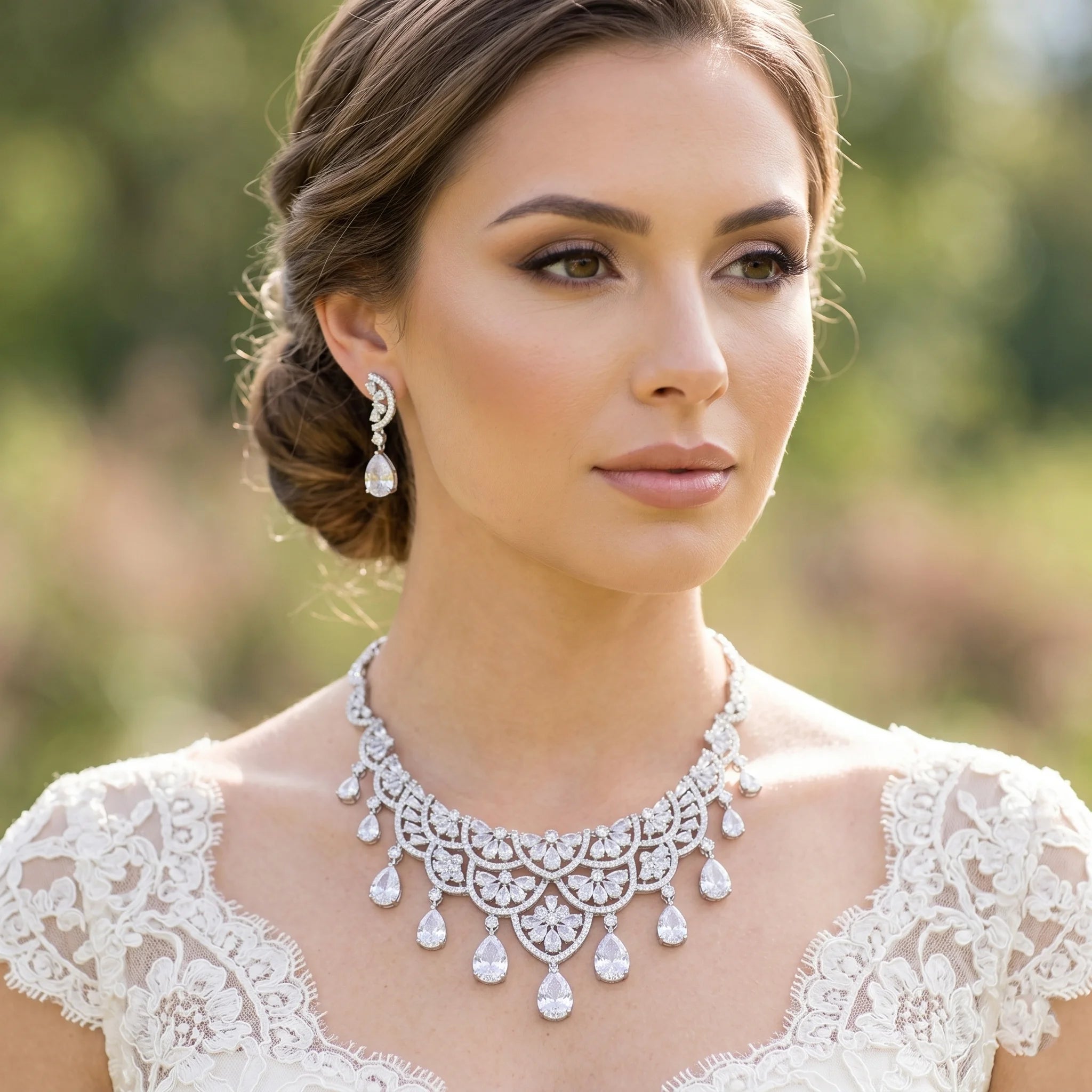 Elegant bride wearing a luxury silver water drop bridal necklace set with matching teardrop earrings