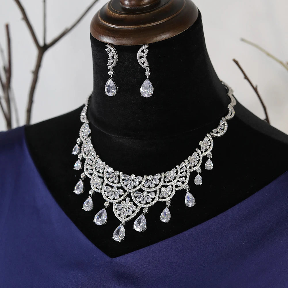 Side angle display of a sparkling crystal water drop wedding necklace set on a dark jewelry stand