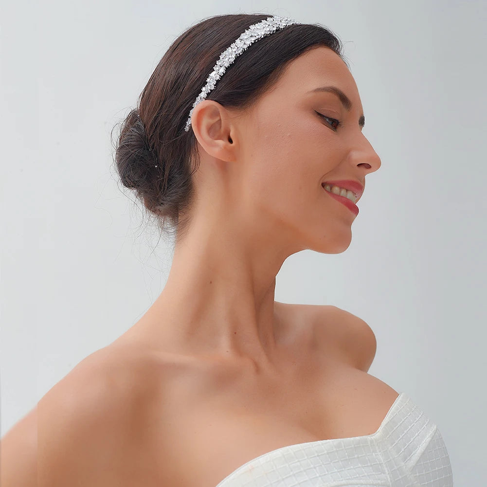 Side profile of a smiling model wearing a luxury CZ bridal headband with a clustered silver wedding hair design.