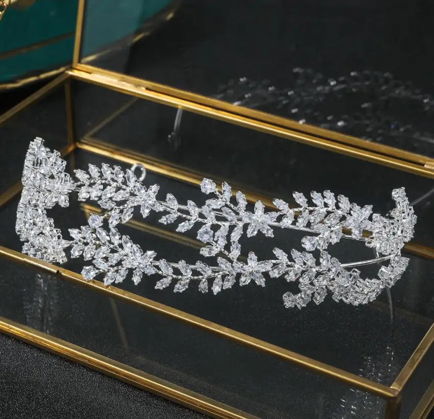 A luxury bridal tiara crown displayed in a glass jewelry box for an elegant presentation.