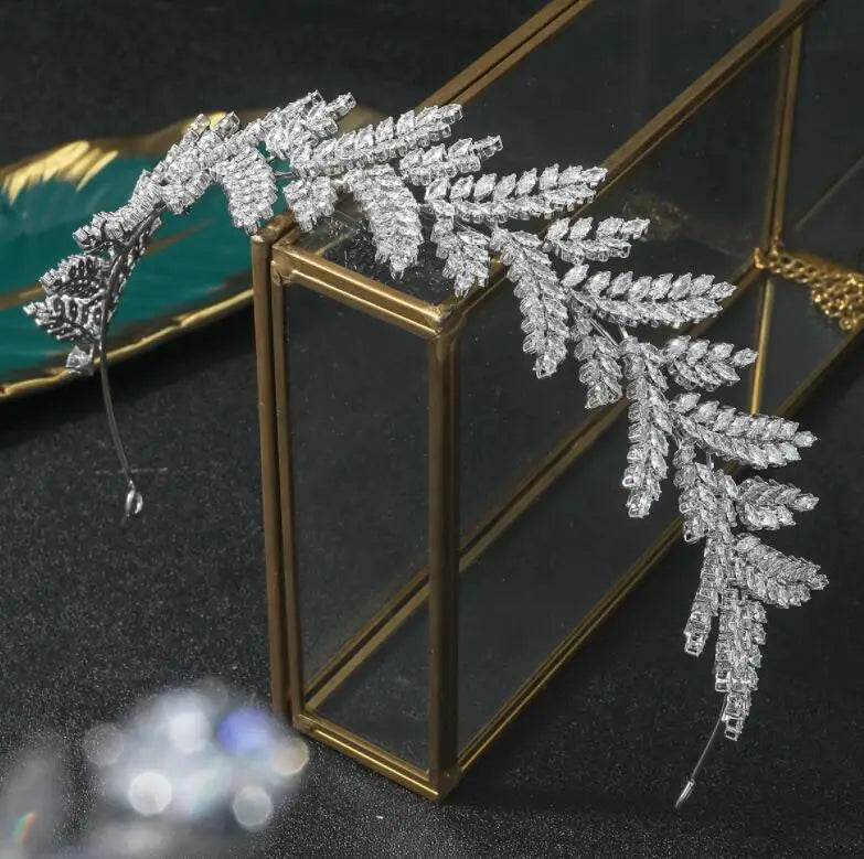Close-up view of a high-end cubic zirconia wedding tiara crown, showcasing the detailed marquise-cut crystal leaf pattern and elegant metal finish.