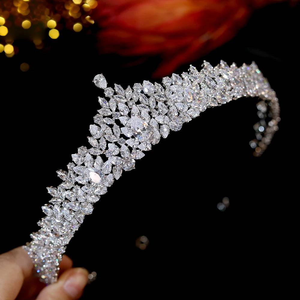 High-angle side view of a sparkling cubic zirconia wedding tiara headband showing a cluster leaf arrangement held in a hand.