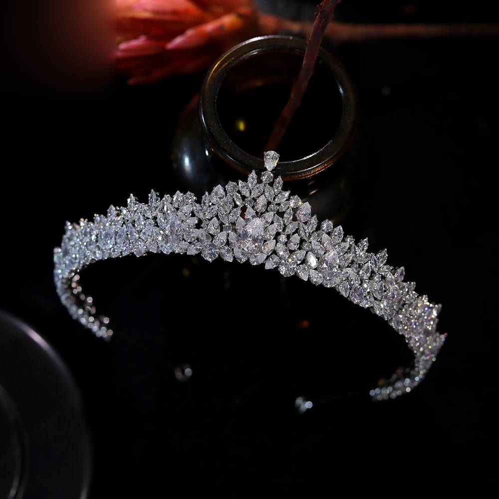 Direct top-down view of an elegant rhinestone wedding headband tiara against a dark backdrop with a glass vase prop.