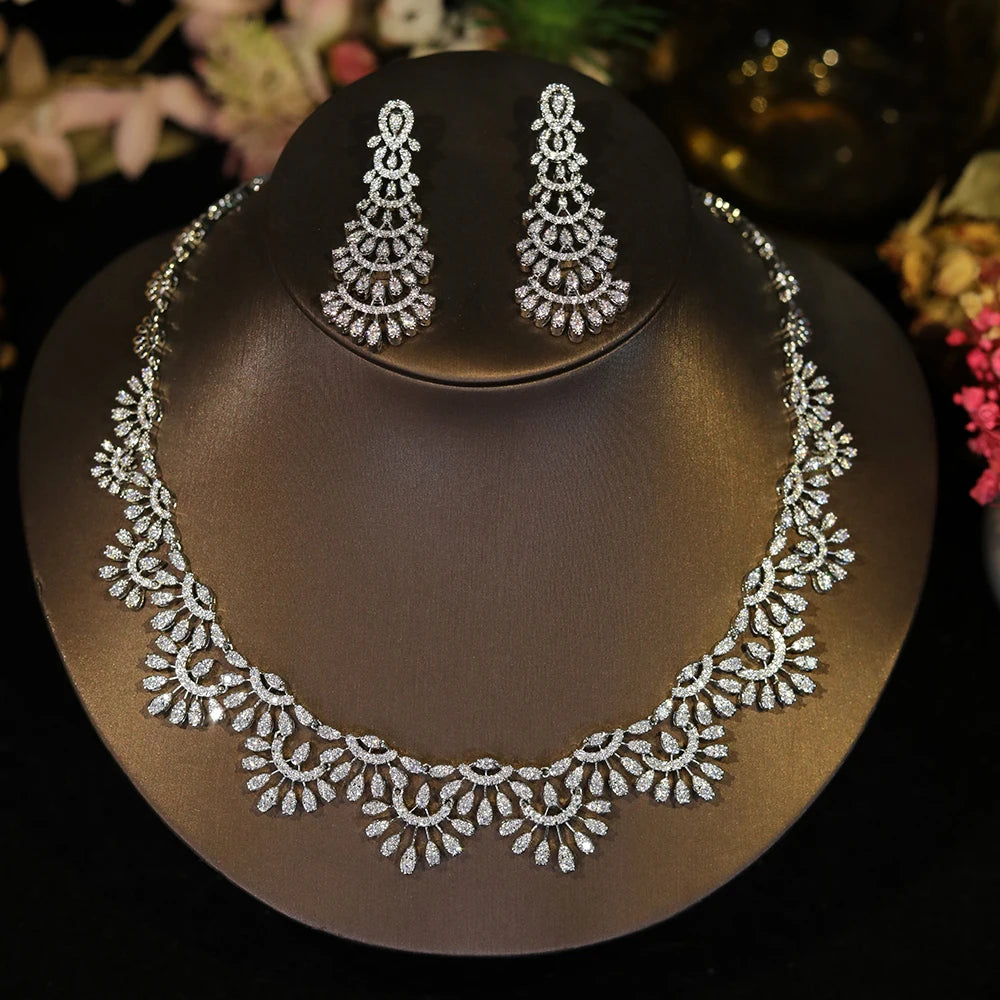 Direct front view of a sparkling cubic zirconia bridal necklace and chandelier earring set on a dark jewelry bust.