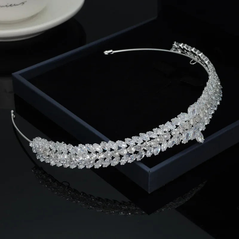 An elegant silver crystal tiara crown inside a dark jewelry storage box.