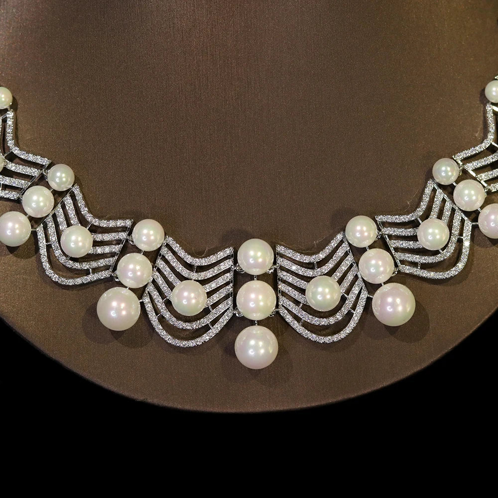 Close-up shot showing the detailed chevron pave setting and cascading white pearls on a bridal choker necklace.