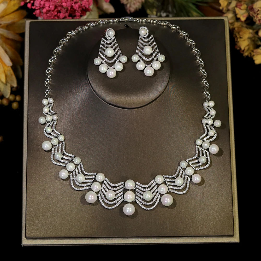 Full product view of a white pearl and cubic zirconia bridal necklace set presented on a classic square display plaque.