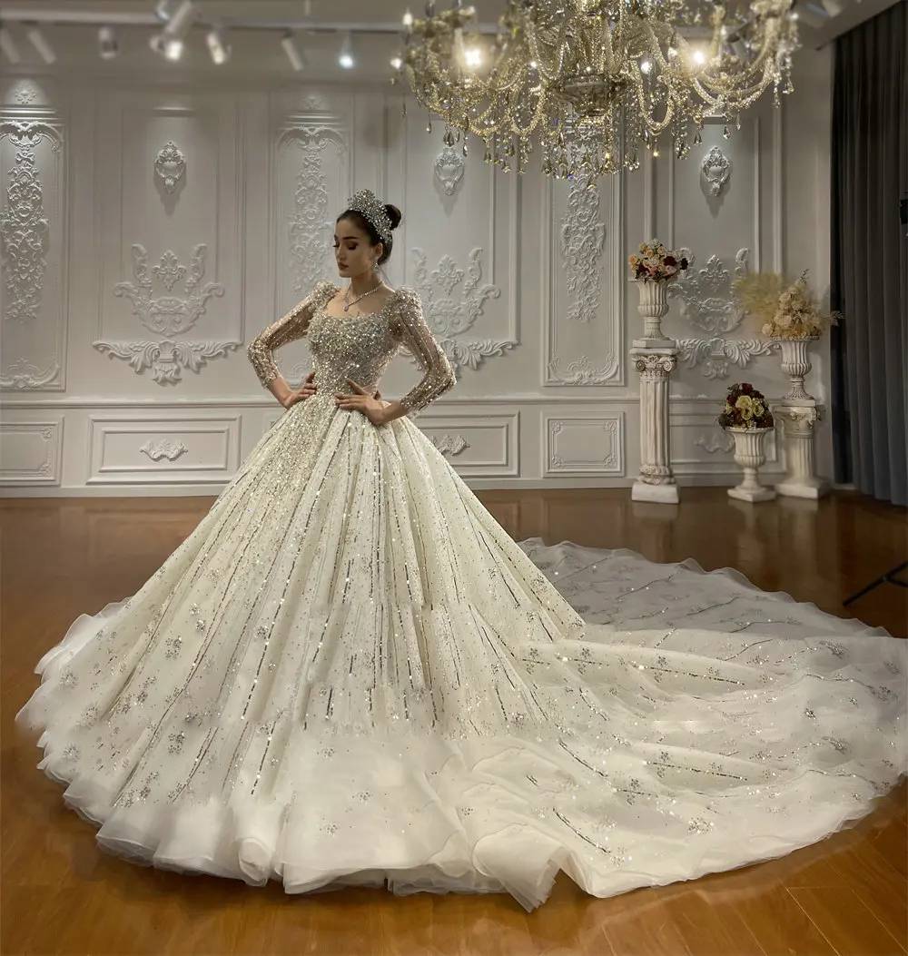 Full-length view of a majestic shimmering cathedral train on a royal Dubai-style wedding dress, featuring wide-sweep sparkle detailing and silver embroidery.